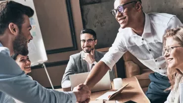 Group of professionals smiling during a meeting.